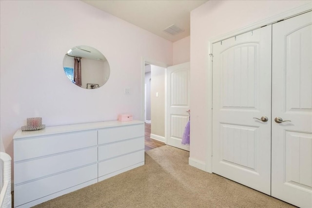 unfurnished bedroom featuring a closet and light colored carpet