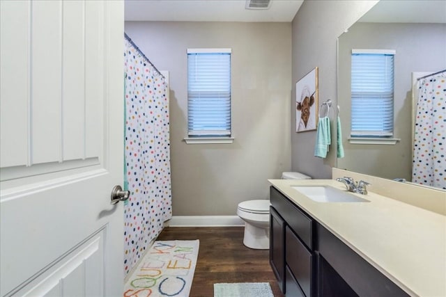 bathroom with vanity, walk in shower, toilet, and hardwood / wood-style floors