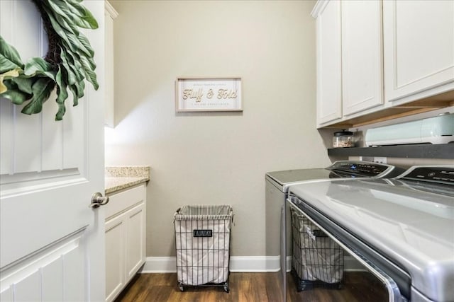 clothes washing area featuring cabinets, washer and clothes dryer, and dark hardwood / wood-style flooring