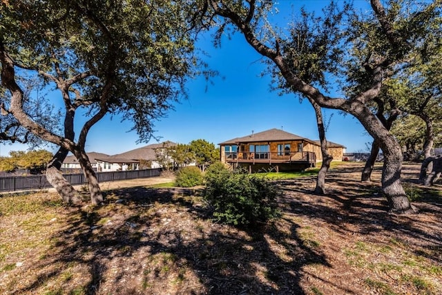 back of property with a wooden deck and fence