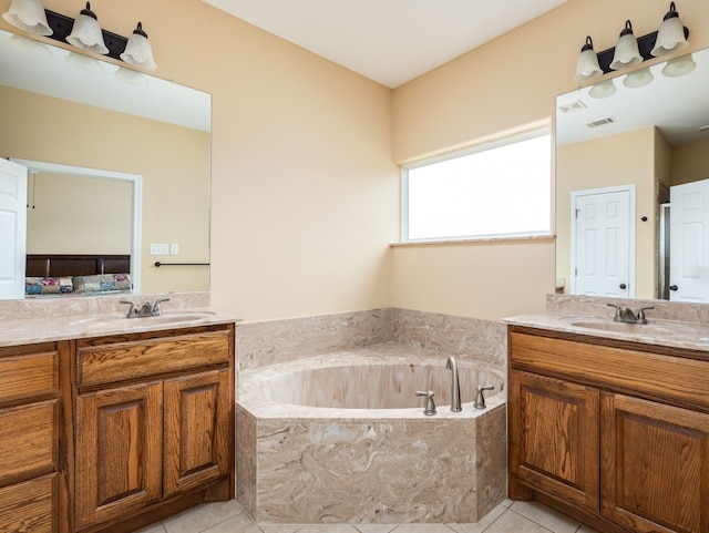 bathroom with vanity, tiled tub, and tile patterned flooring