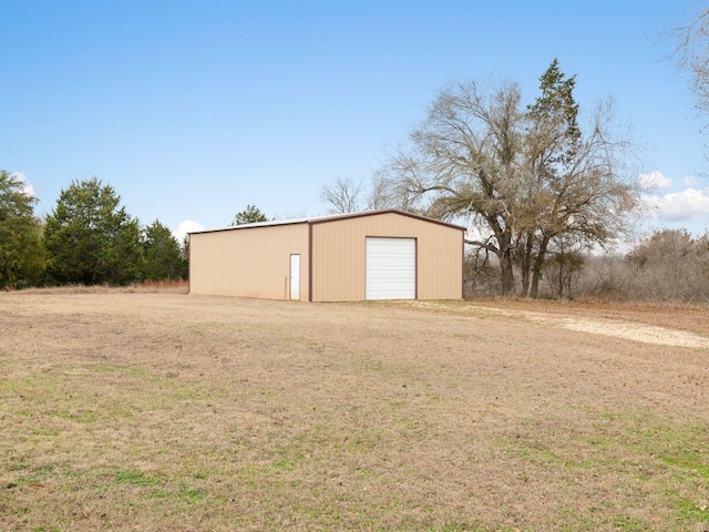 view of outbuilding featuring a garage and a lawn