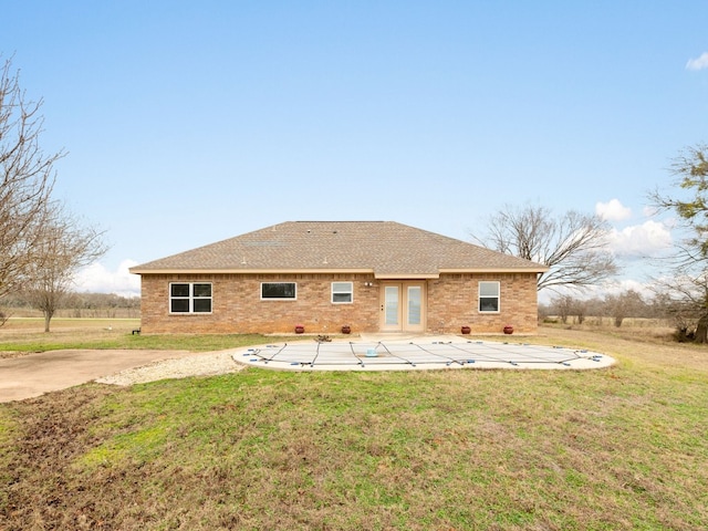1504 County Road 459, Thorndale, TX 76577 - rear view of property featuring a yard, a patio, a shingled roof, and a covered pool