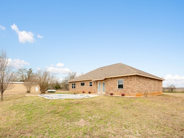 1504 County Road 459, Thorndale, TX 76577 - back of property with a patio, a lawn, and brick siding