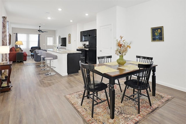 dining area with ceiling fan, sink, and light hardwood / wood-style floors