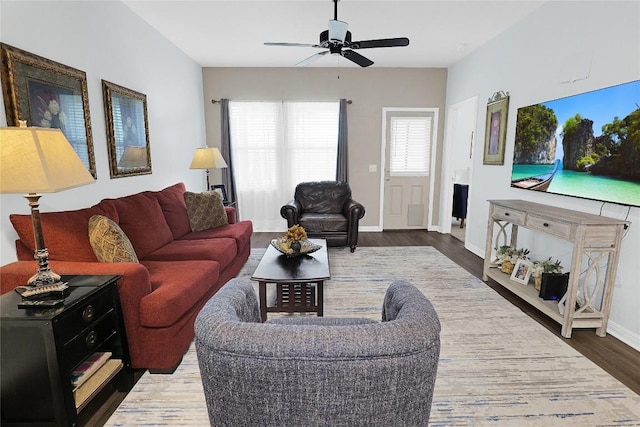 living room featuring dark wood-type flooring and ceiling fan