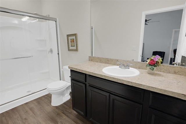 bathroom with hardwood / wood-style flooring, vanity, an enclosed shower, and toilet