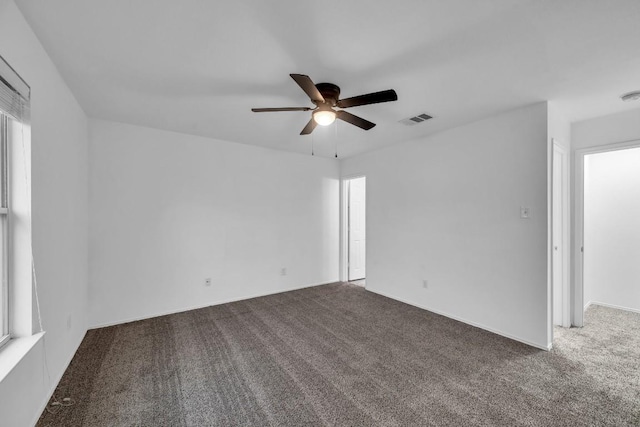 carpeted spare room featuring ceiling fan