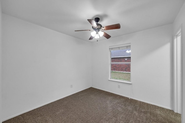 spare room featuring ceiling fan and dark colored carpet