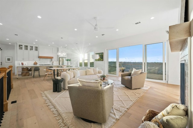 living room with ceiling fan and light hardwood / wood-style floors