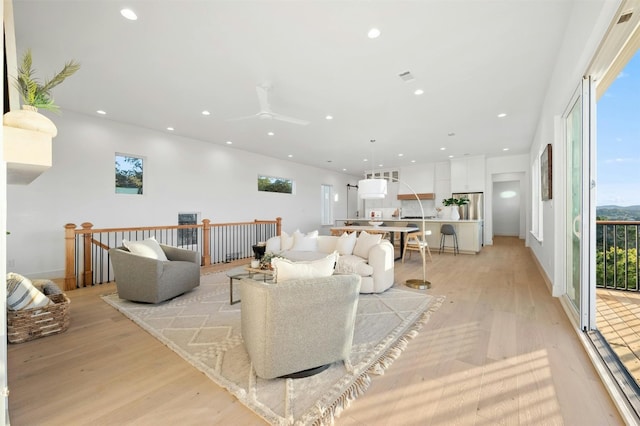 living room with light hardwood / wood-style floors and ceiling fan