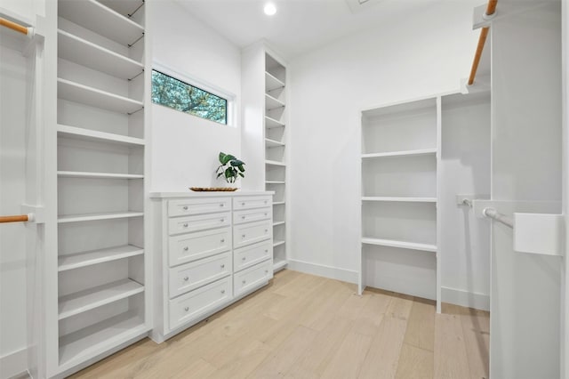 walk in closet with light hardwood / wood-style flooring