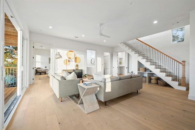 living room with a wealth of natural light, ceiling fan, and light wood-type flooring