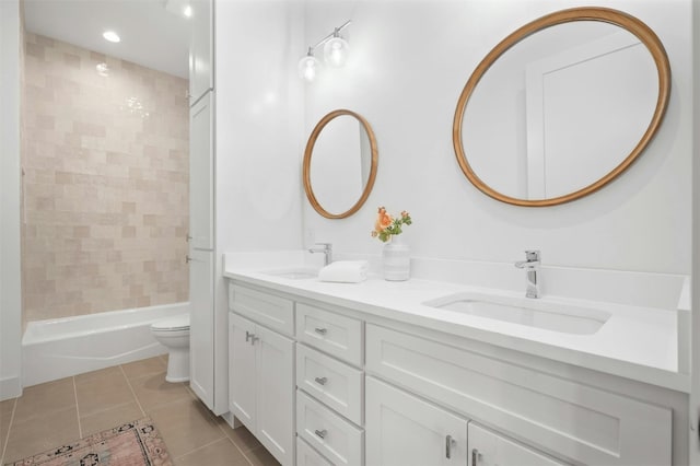 full bathroom featuring tile patterned flooring, tiled shower / bath, vanity, and toilet