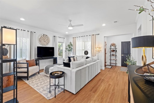 living area featuring light wood-style floors, ornamental molding, a ceiling fan, and recessed lighting