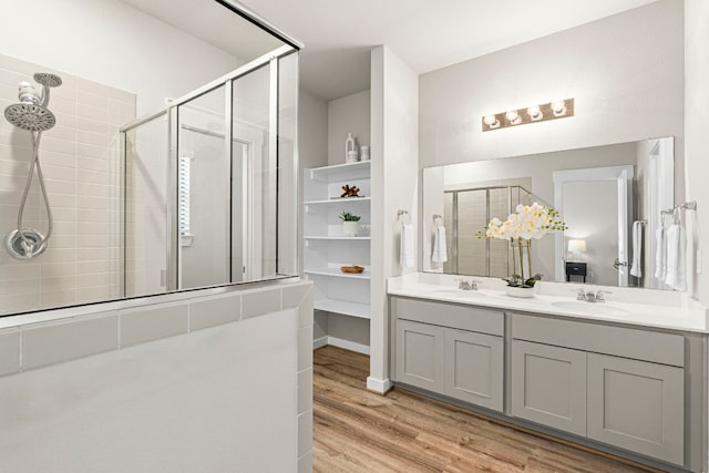 bathroom featuring walk in shower, vanity, and hardwood / wood-style floors