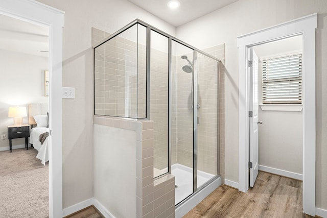 bathroom featuring hardwood / wood-style flooring and a shower with shower door