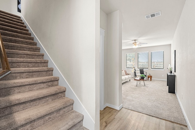 stairs with ceiling fan and wood-type flooring