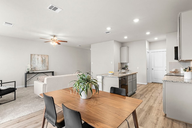 dining room featuring sink, light hardwood / wood-style floors, and ceiling fan