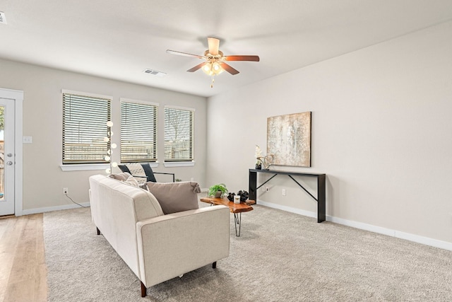 carpeted living room featuring ceiling fan