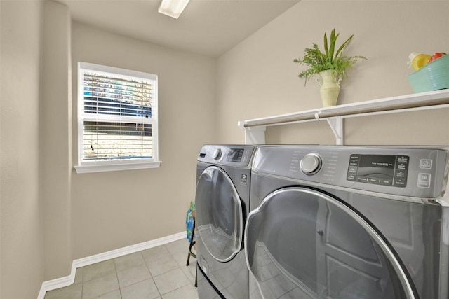 laundry area with light tile patterned floors and washing machine and clothes dryer