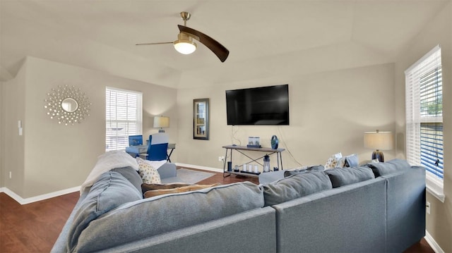 living room with dark wood-type flooring, ceiling fan, plenty of natural light, and a raised ceiling