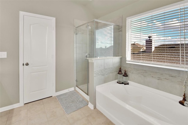 full bath featuring a shower stall, baseboards, a bath, and tile patterned floors