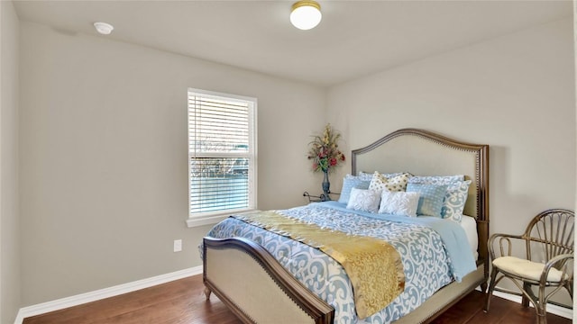 bedroom with baseboards and dark wood-type flooring