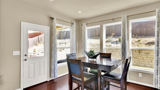 dining space featuring dark wood finished floors and baseboards