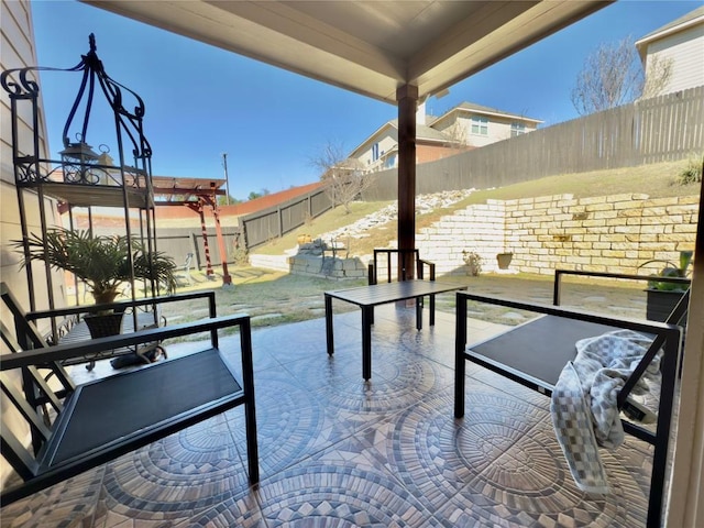 exterior space featuring outdoor dining area, a patio area, and a fenced backyard