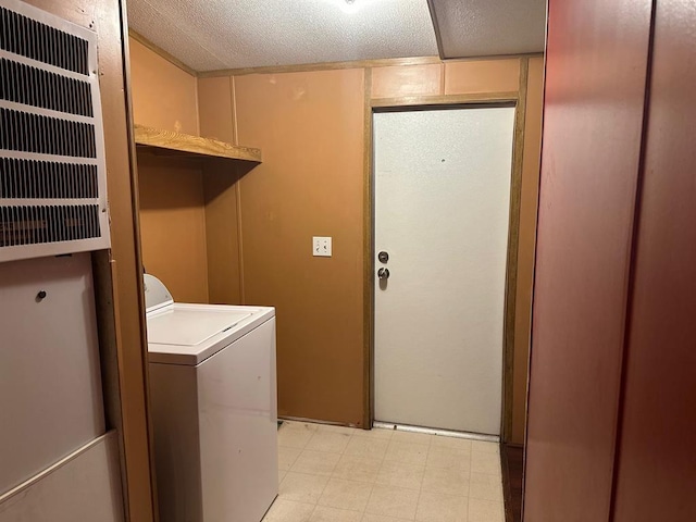 clothes washing area featuring washer / clothes dryer and a textured ceiling