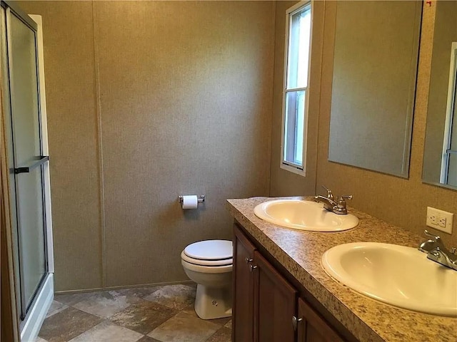 bathroom with walk in shower, vanity, and toilet