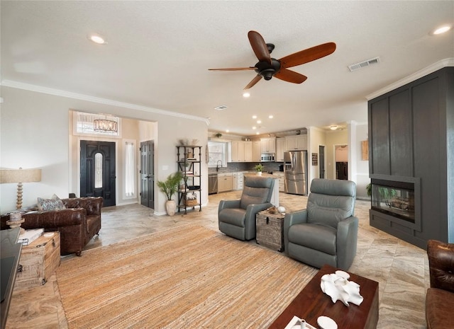 112 Chaumont St, Kingsland, TX 78639 - living room featuring a ceiling fan, ornamental molding, recessed lighting, and a glass covered fireplace
