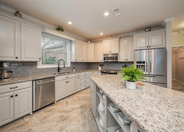 112 Chaumont St, Kingsland, TX 78639 - kitchen with a sink, stainless steel appliances, visible vents, backsplash, and ornamental molding
