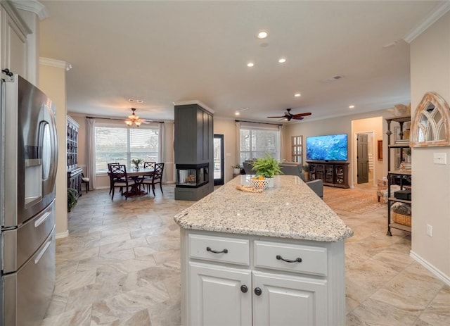 112 Chaumont St, Kingsland, TX 78639 - kitchen featuring a ceiling fan, a center island, ornamental molding, open floor plan, and stainless steel refrigerator with ice dispenser