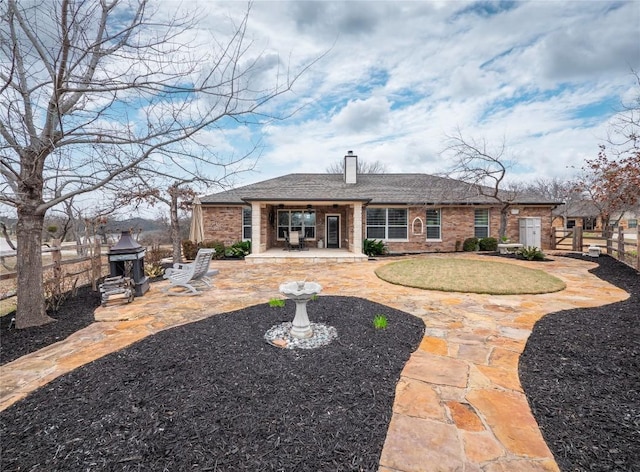 112 Chaumont St, Kingsland, TX 78639 - back of house featuring fence, brick siding, a patio, a chimney, and a shingled roof