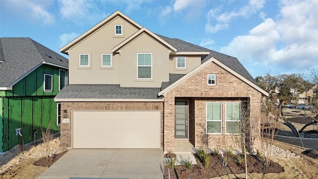 view of front of property featuring an attached garage, brick siding, a shingled roof, driveway, and stucco siding