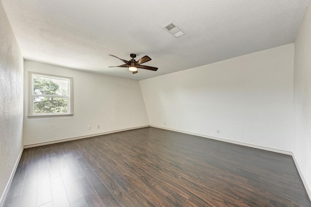 unfurnished room featuring dark wood-type flooring, ceiling fan, and a textured ceiling