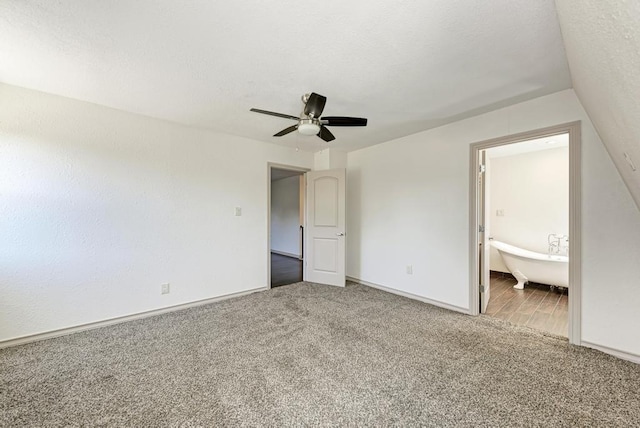 unfurnished bedroom with ceiling fan, ensuite bath, carpet flooring, and a textured ceiling