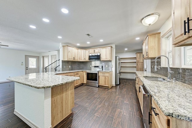 kitchen with sink, dark wood-type flooring, stainless steel appliances, light stone counters, and light brown cabinets