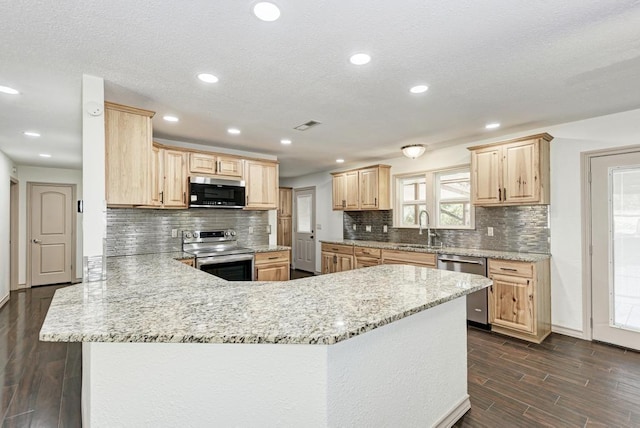 kitchen featuring sink, dark wood-type flooring, appliances with stainless steel finishes, light brown cabinetry, and kitchen peninsula