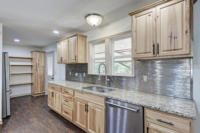 kitchen featuring light brown cabinetry, sink, stainless steel appliances, and light stone countertops