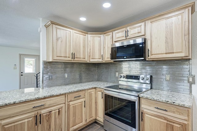 kitchen with light stone counters, stainless steel appliances, tasteful backsplash, and light brown cabinets