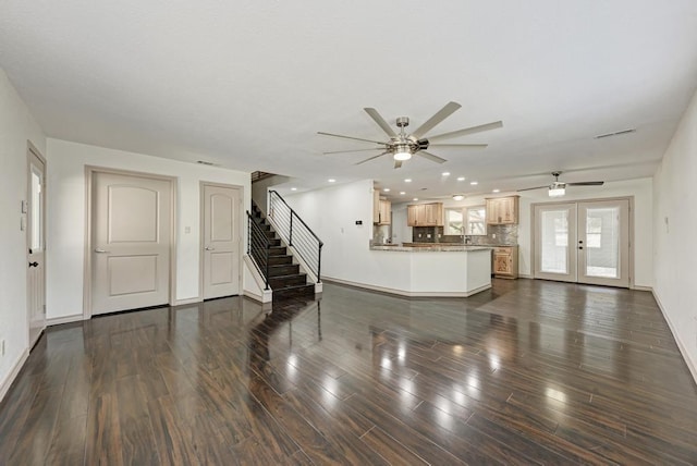 unfurnished living room with dark wood-type flooring, sink, ceiling fan, and french doors