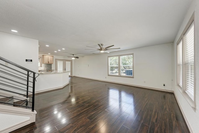 unfurnished living room with ceiling fan and dark hardwood / wood-style floors