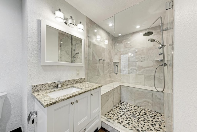 bathroom with vanity, a shower with shower door, and toilet