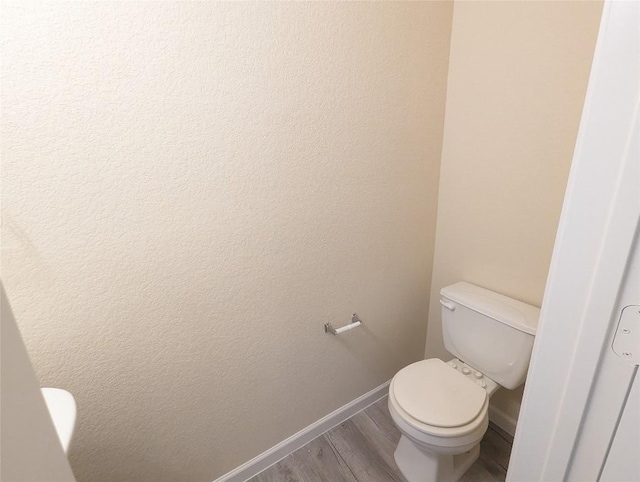 bathroom featuring wood-type flooring and toilet