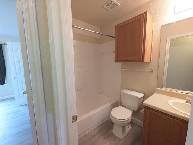 full bathroom featuring vanity, wood-type flooring, bathtub / shower combination, and toilet