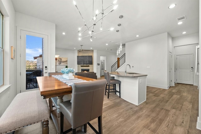 dining space with recessed lighting, light wood-style floors, visible vents, and a large fireplace