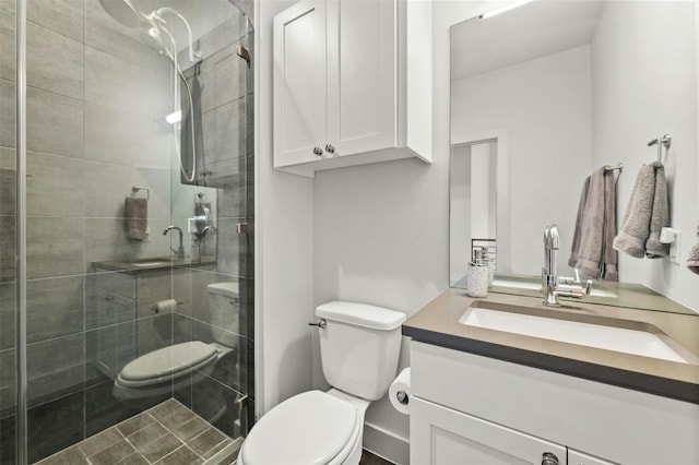 bathroom with vanity, a shower stall, and toilet